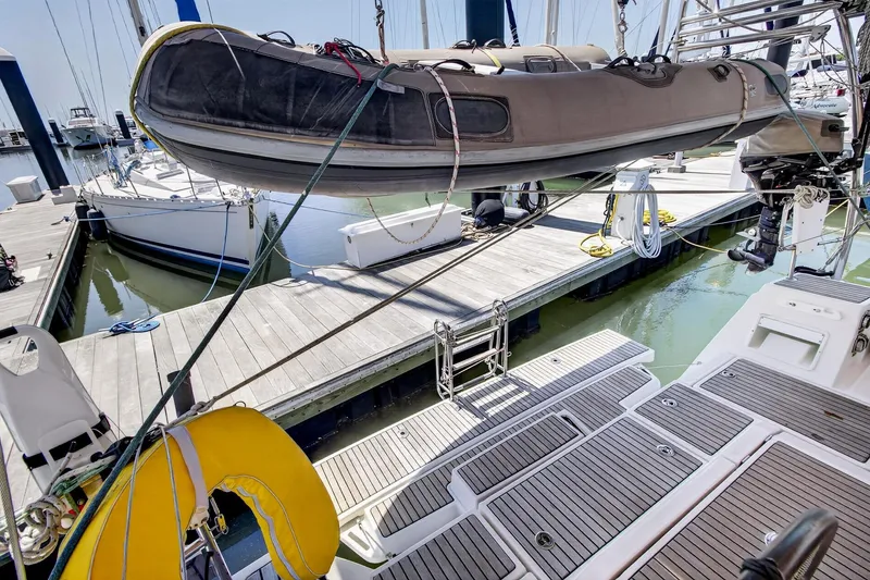 Slide: The Image of Beneteau Oceanis 48 yacht docked, featuring a dinghy and spacious deck, 2012 model. - 56