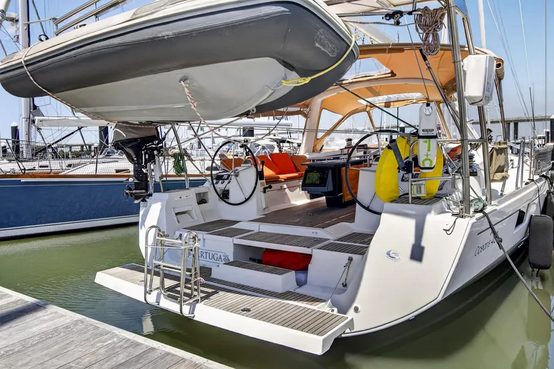 Slide: The Image of Beneteau Oceanis 48 sailboat, 2012 model, docked with dinghy and orange seating. - 57