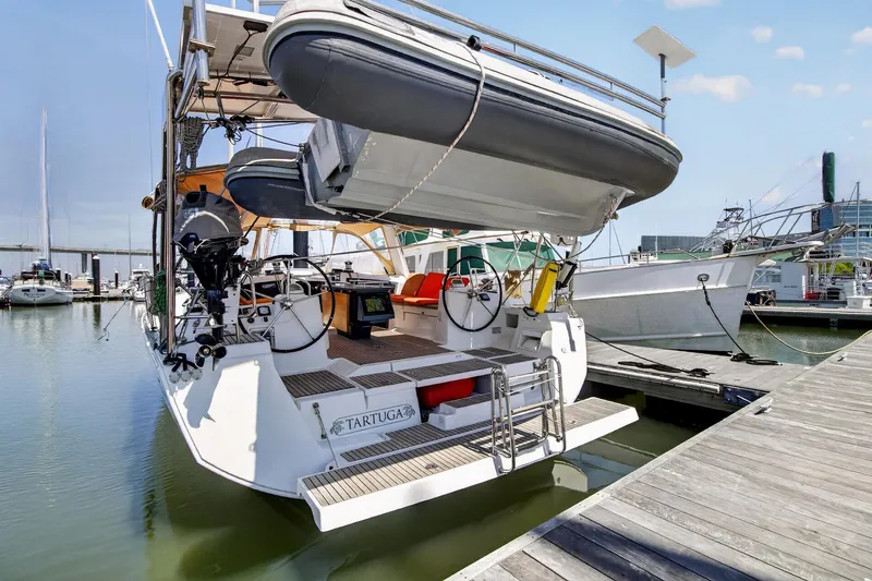 Slide: The Image of Beneteau Oceanis 48 sailboat, 2012 model, docked with dinghy and dual steering wheels. - 58