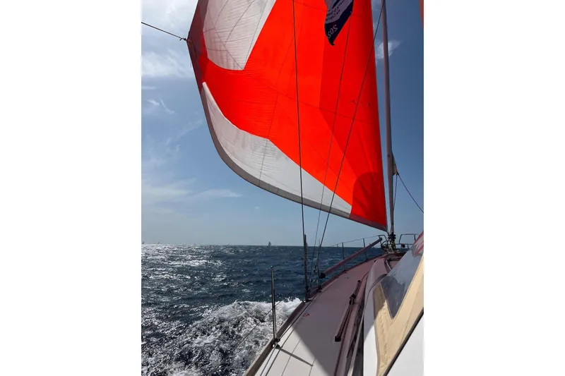 Slide: The Image of Beneteau Oceanis 48 sailing with vibrant red sail on open sea, 2012 model. - 64