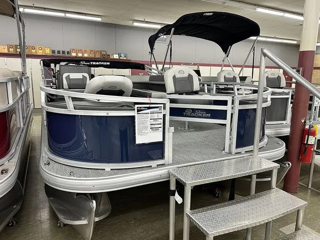 Slide: The Image of 2026 Sun Tracker Bass Buggy 18 DLX pontoon boat in showroom. - 3