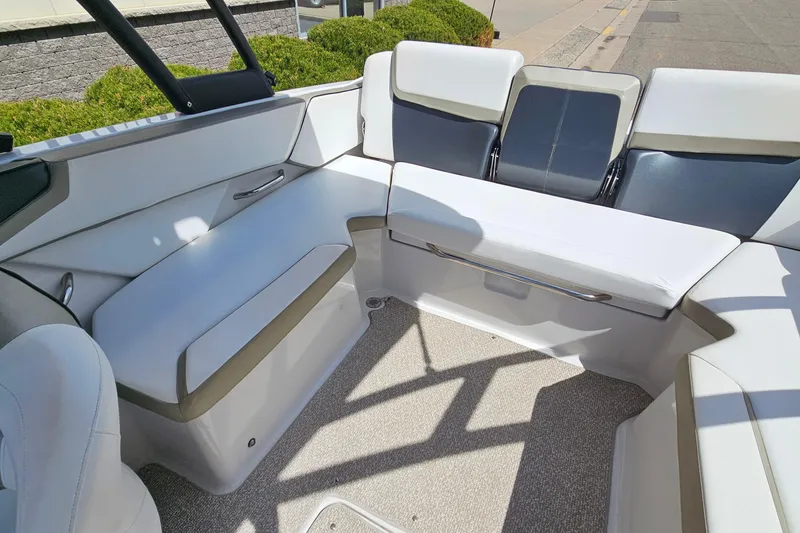 Slide: The Image of Interior seating of a 2014 Scarab 215 boat, featuring white and gray upholstery. - 11