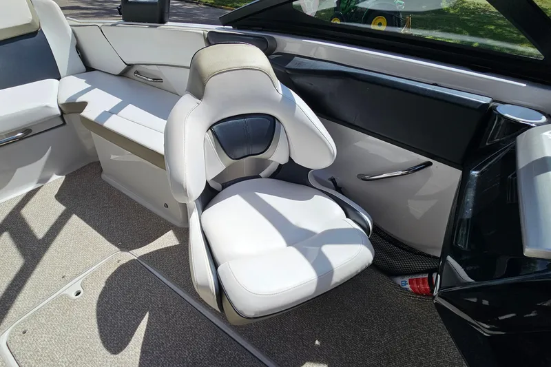 Slide: The Image of Interior of a 2014 Scarab 215 boat featuring a sleek, modern white seat design. - 12