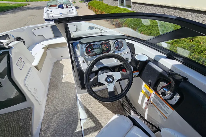 Slide: The Image of Interior view of a 2014 Scarab 215 boat cockpit with steering wheel and dashboard. - 14