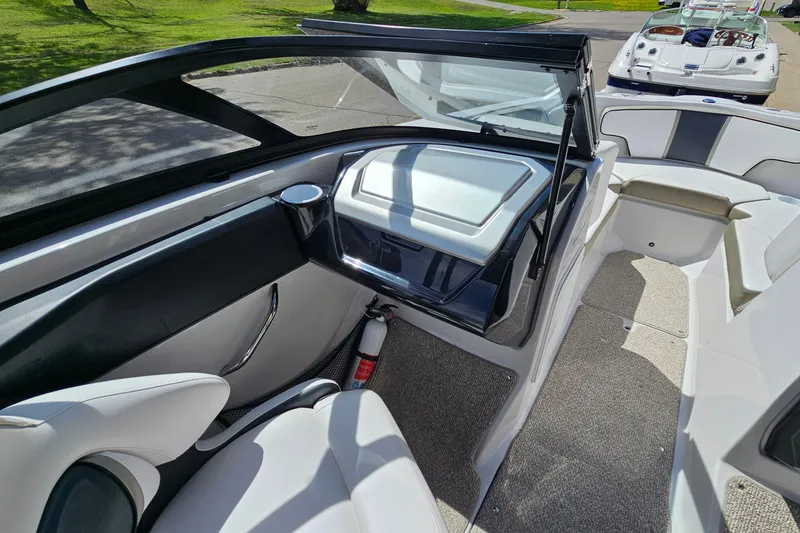 Slide: The Image of Interior of a 2014 Scarab 215 boat, featuring seating and storage compartments. - 15