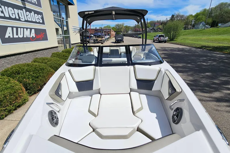 Slide: The Image of 2014 Scarab 215 boat with white seating, parked outdoors near dealership. - 19