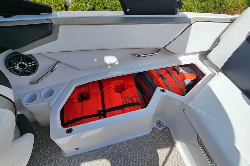 Slide: The Image of Storage compartment in a 2014 Scarab 215 boat with life jackets. - 21