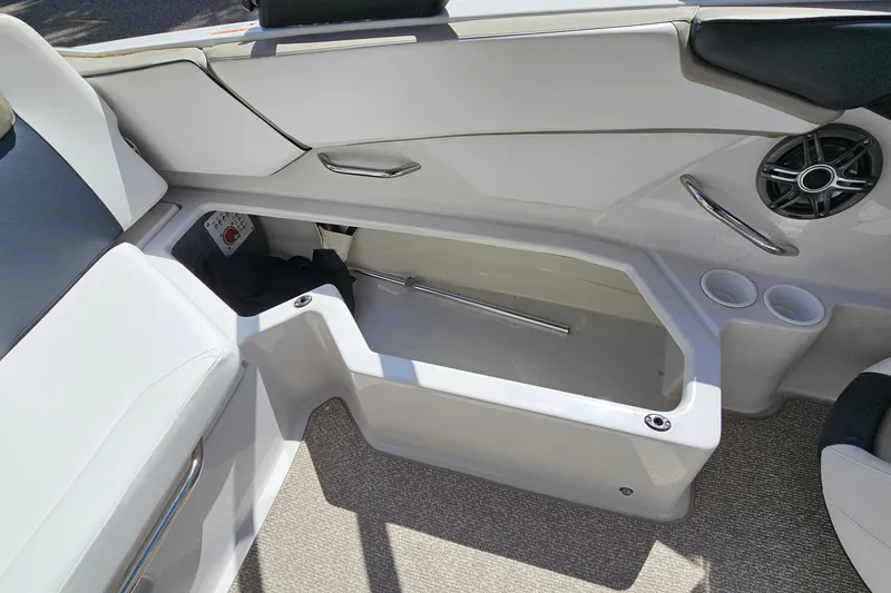 Slide: The Image of 2014 Scarab 215 boat interior storage compartment with speaker and cup holders. - 22
