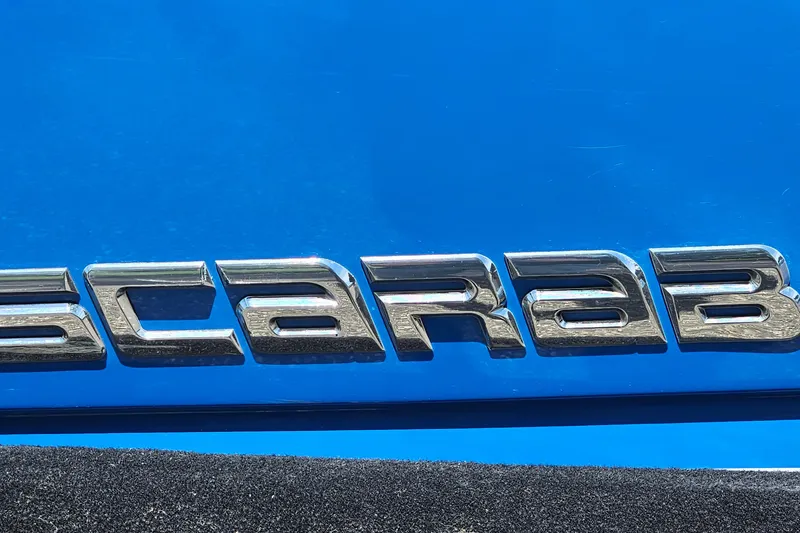 Slide: The Image of Chrome "Scarab" emblem on a blue 2014 Scarab 215 boat. - 28