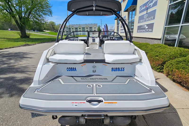 Slide: The Image of 2014 Scarab 215 boat with "Cobra Bubbles" text, parked near a dealership. - 5