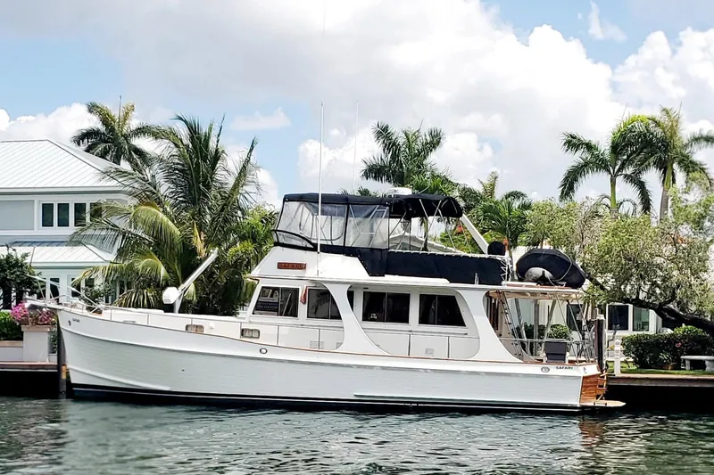 The Image of Grand Banks 46 Europa 1997 yacht docked by palm trees and waterfront homes. - 3