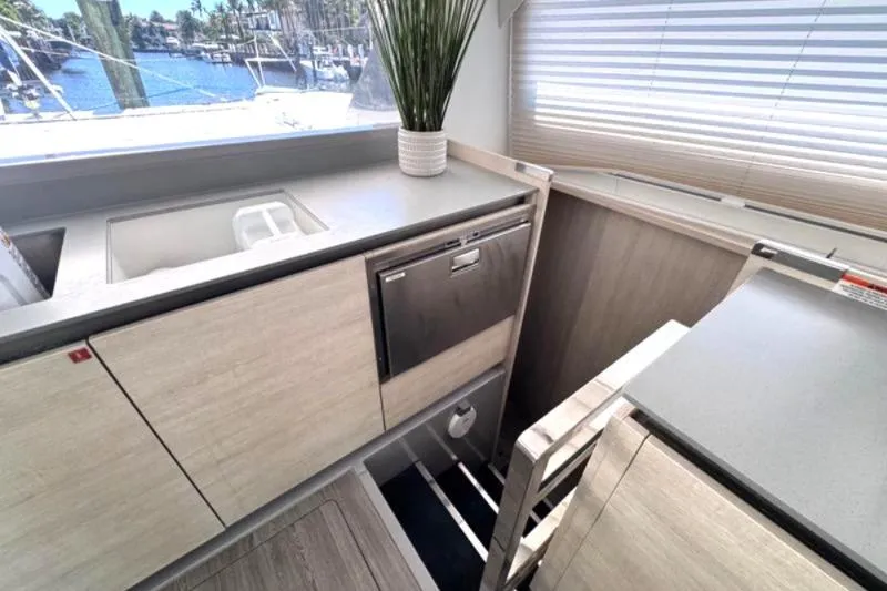 Slide: The Image of Modern kitchen area on a 2020 Leopard 50 yacht with sleek cabinetry and a scenic view. - 16