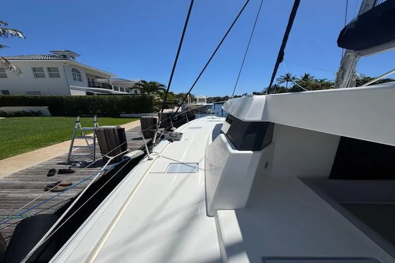 Slide: The Image of 2020 Leopard 50 yacht docked near a waterfront property under clear blue skies. - 26