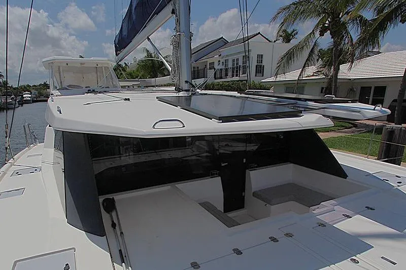 Slide: The Image of Catamaran Leopard 50, 2020 model, docked near palm trees and waterfront homes. - 28