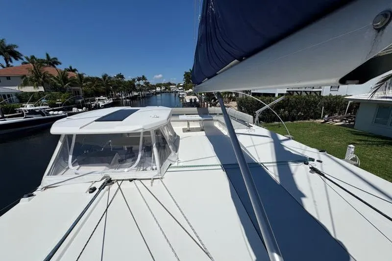 Slide: The Image of Leopard 50 catamaran docked in a sunny canal, showcasing sleek design and spacious deck. - 34