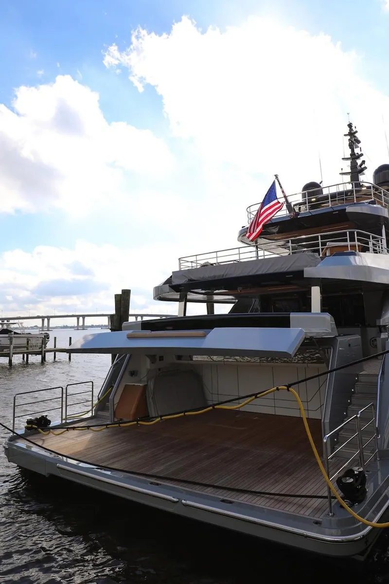 Slide: The Image of Luxury Majesty 120 yacht, 2025 model, docked with American flag, under a bright sky. - 29