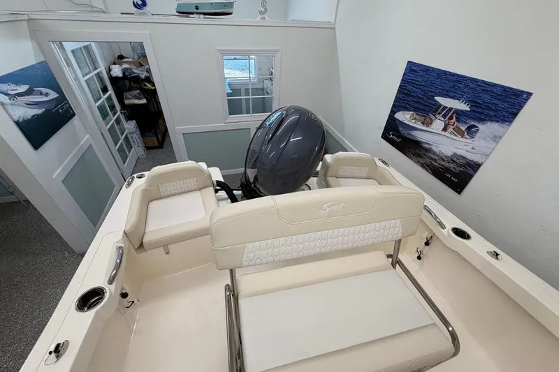 Slide: The Image of 2026 Scout 188 Sportfish boat interior with seating and motor in showroom. - 3