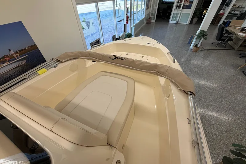 Slide: The Image of 2026 Scout 188 Sportfish boat interior in showroom, featuring beige seating and sleek design. - 6