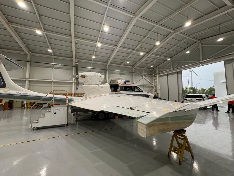 Slide: The Image of 2025 Aron M 80 aircraft in spacious hangar with open doors. - 16