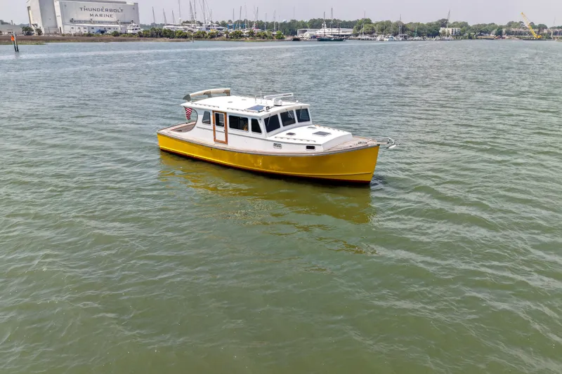 Slide: The Image of Yellow Redfern Mitchell Cove 32 boat from 2001 on calm water near Thunderbolt Marine. - 10