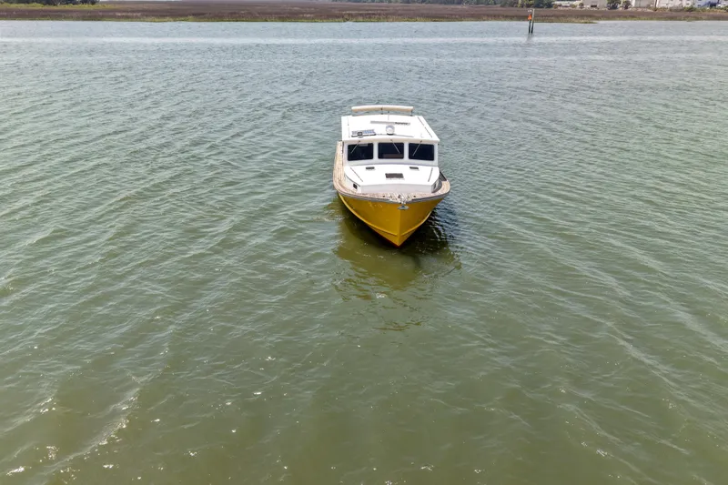 Slide: The Image of Yellow Redfern Mitchell Cove 32 boat from 2001 on calm water. - 11