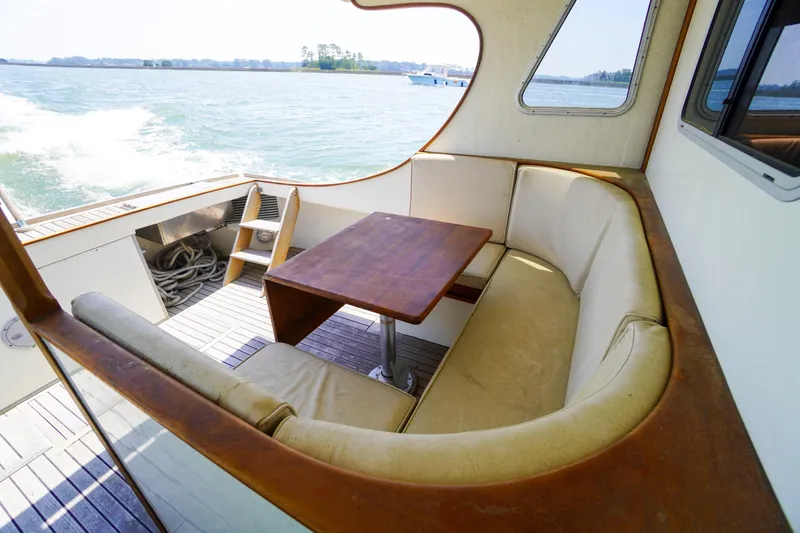 Slide: The Image of Cozy seating area on 2001 Redfern Mitchell Cove 32 boat, overlooking serene waters. - 14