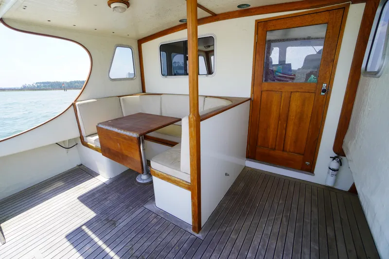 Slide: The Image of Interior of 2001 Redfern Mitchell Cove 32 boat with wooden seating and table. - 16