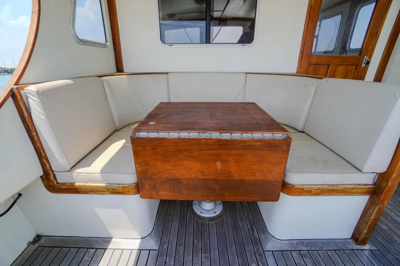 Slide: The Image of Cozy seating area on 2001 Redfern Mitchell Cove 32 boat with wooden table. - 17