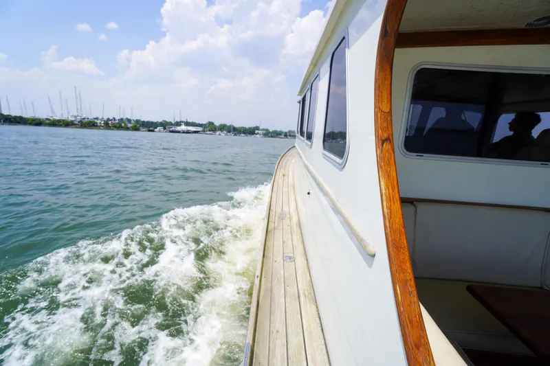 Slide: The Image of Side view of a 2001 Redfern Mitchell Cove 32 boat cruising on a sunny day. - 18