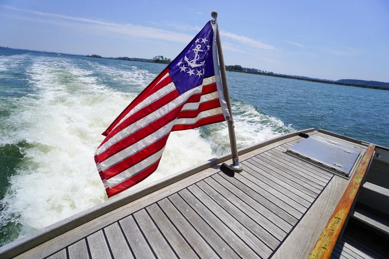Slide: The Image of Redfern Mitchell Cove 32 boat with nautical flag, cruising on open water, 2001 model. - 20