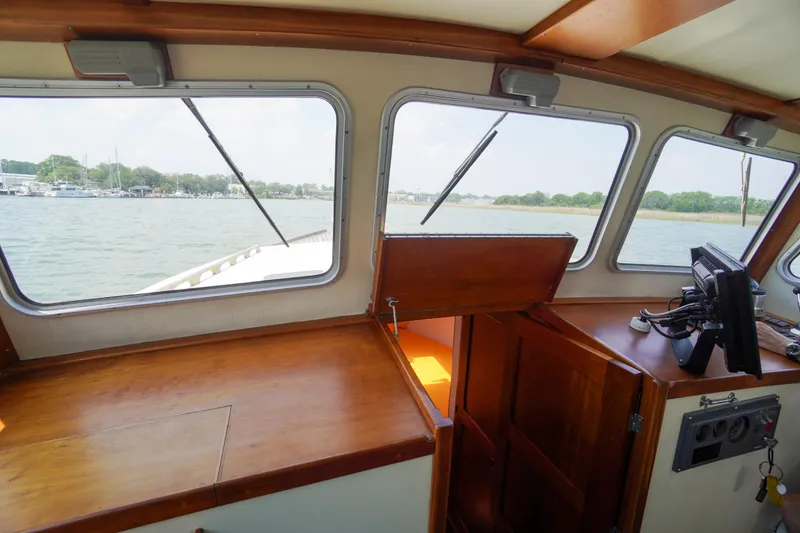 Slide: The Image of Interior view of 2001 Redfern Mitchell Cove 32 boat with wooden dashboard and windows. - 21