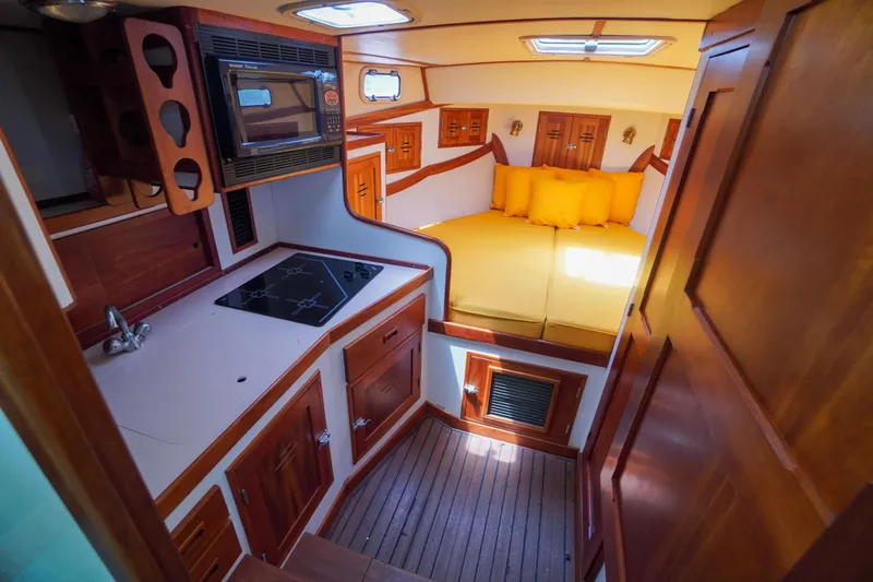 Slide: The Image of Interior of 2001 Redfern Mitchell Cove 32 boat with kitchen and cozy sleeping area. - 22