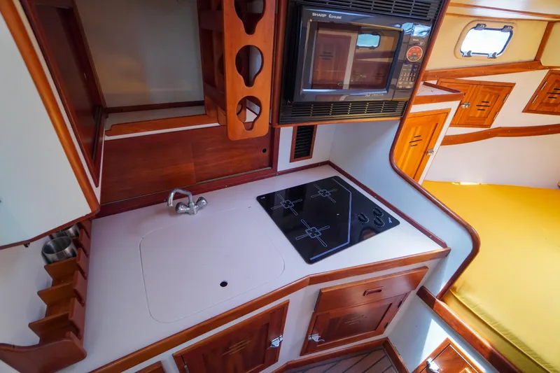 Slide: The Image of Compact kitchen area in a 2001 Redfern Mitchell Cove 32 boat, featuring stove and microwave. - 23