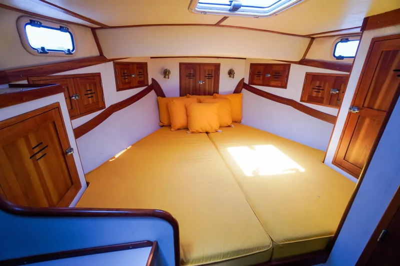 Slide: The Image of Cozy cabin interior of 2001 Redfern Mitchell Cove 32 with yellow bedding and wooden cabinets. - 25