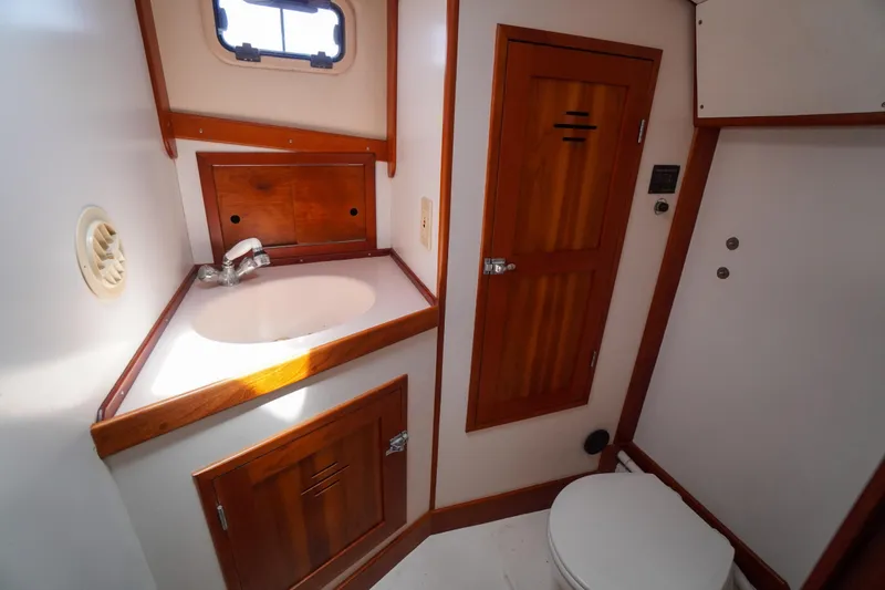 Slide: The Image of Compact bathroom in 2001 Redfern Mitchell Cove 32 boat with wooden cabinetry and white fixtures. - 26
