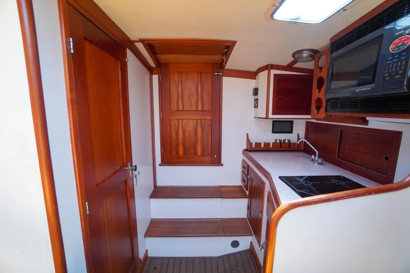 Slide: The Image of Interior of 2001 Redfern Mitchell Cove 32 boat with wooden cabinetry and compact kitchen. - 29