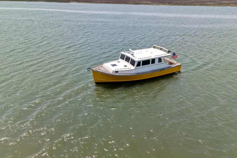 Slide: The Image of Yellow Redfern Mitchell Cove 32 boat from 2001 on calm water. - 3
