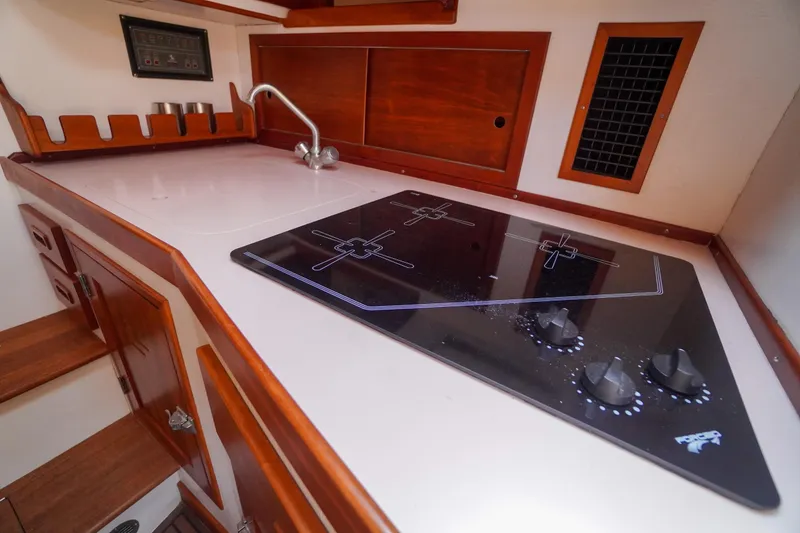 Slide: The Image of Compact galley kitchen in 2001 Redfern Mitchell Cove 32 boat with modern stovetop. - 30
