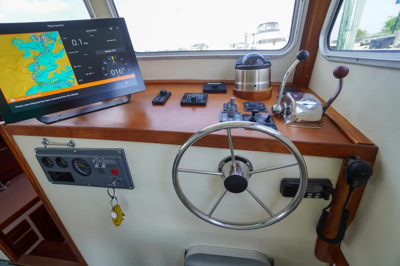 Slide: The Image of Helm of 2001 Redfern Mitchell Cove 32 with navigation equipment and steering wheel. - 32