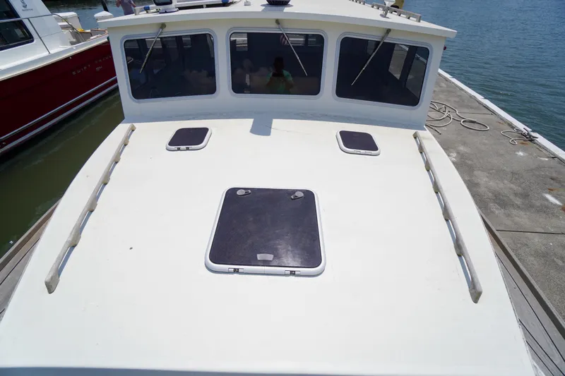 Slide: The Image of 2001 Redfern Mitchell Cove 32 boat docked, showcasing deck and cabin windows. - 33