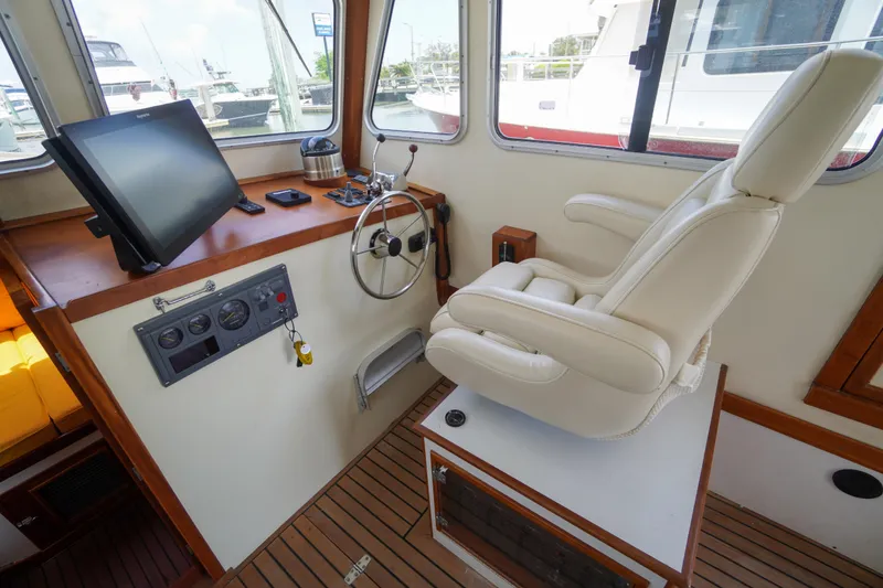 Slide: The Image of Cabin interior of 2001 Redfern Mitchell Cove 32 with steering wheel and captain's chair. - 44