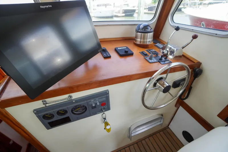 Slide: The Image of Helm of 2001 Redfern Mitchell Cove 32 with steering wheel and navigation equipment. - 47