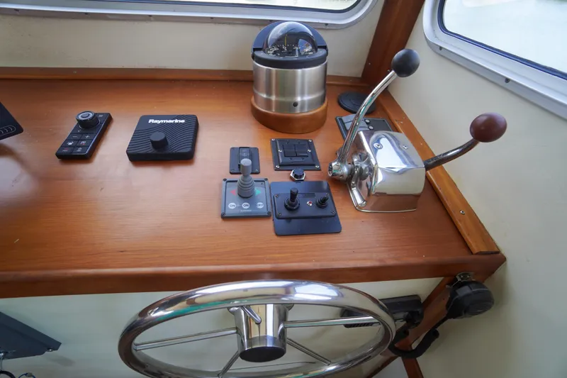 Slide: The Image of Control panel of a 2001 Redfern Mitchell Cove 32 boat with steering wheel and navigation instruments. - 48