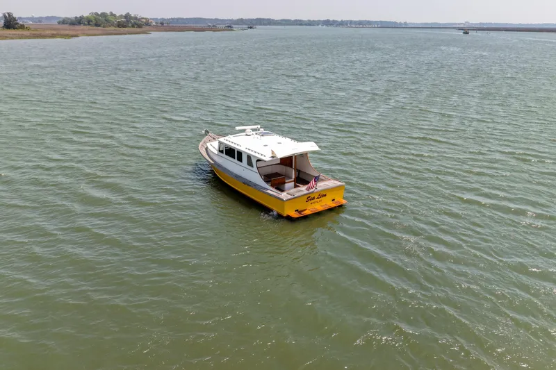 Slide: The Image of A 2001 Redfern Mitchell Cove 32 boat cruising on a calm lake. - 5