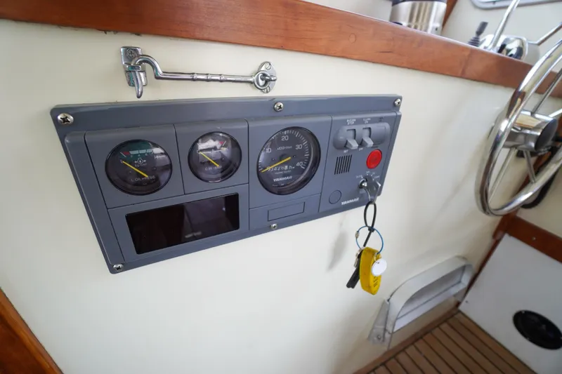 Slide: The Image of Control panel of a 2001 Redfern Mitchell Cove 32 boat with gauges and keys. - 50