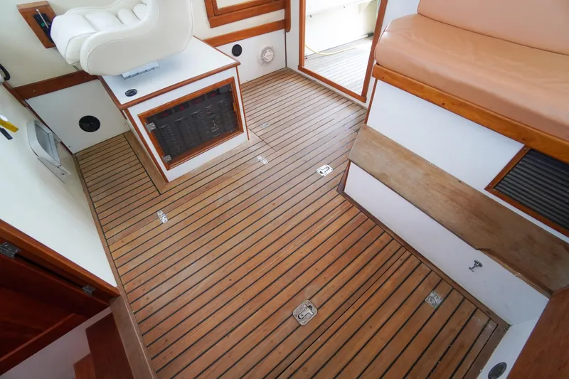 Slide: The Image of Interior of 2001 Redfern Mitchell Cove 32 boat with wooden flooring and seating. - 52