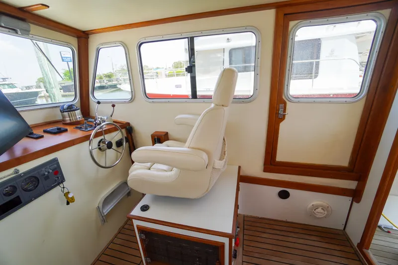 Slide: The Image of Interior of 2001 Redfern Mitchell Cove 32 boat with steering wheel and captain's chair. - 53