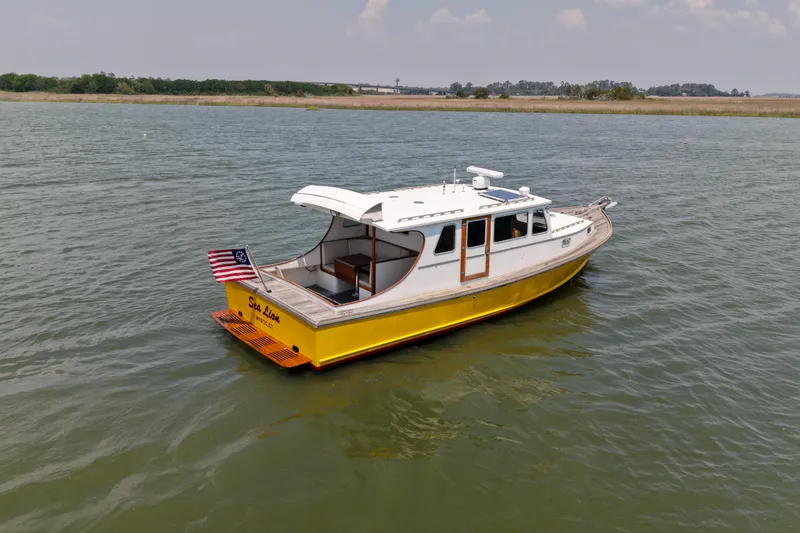 Slide: The Image of Yellow 2001 Redfern Mitchell Cove 32 boat on water with American flag. - 8