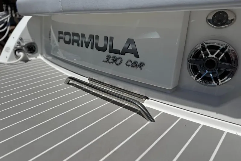 Slide: The Image of 2025 Formula 330 Crossover Bowrider OB boat deck with speakers and branding. - 11
