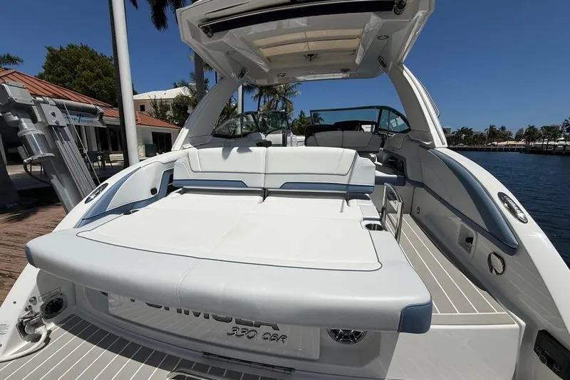 Slide: The Image of 2025 Formula 330 Crossover Bowrider OB, luxurious seating, docked by waterfront. - 14